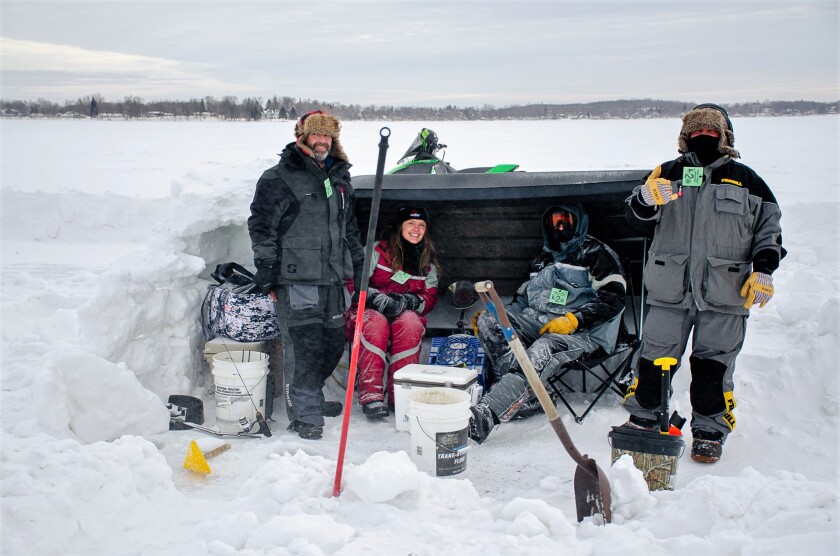 A group of ice anglers pose for a picture during the 2022 Poles 'N Holes derby on Little Detroit Lake.