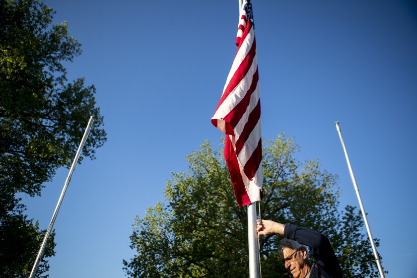 Dale Johnson raises an American flag at the Flags of Honor Memorial in Willmar on Friday, May 27, 2022.