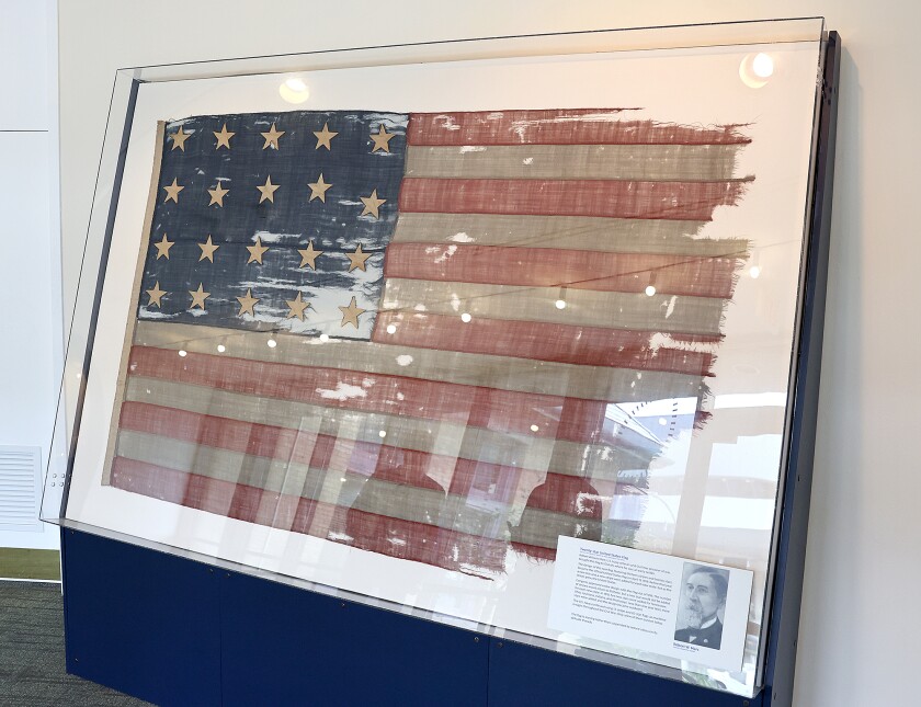 Civil War flag behind glass.