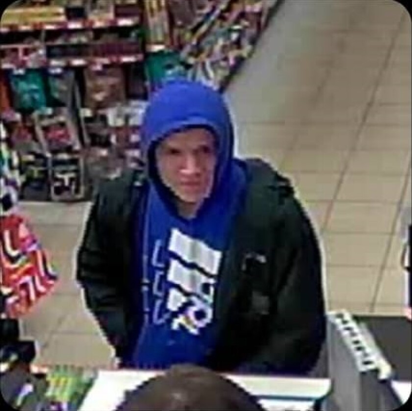 man in hooded sweatshirt at counter in gas station