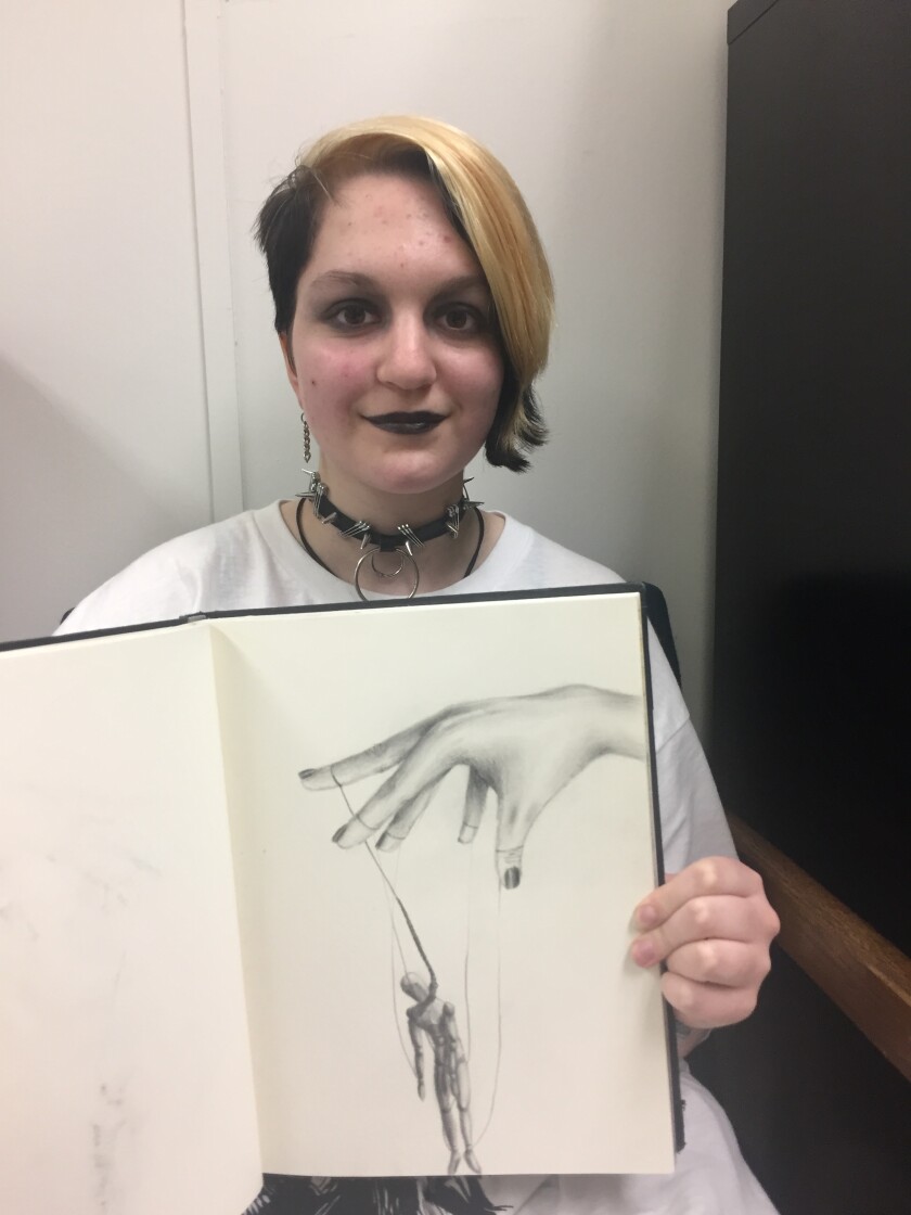 Brainerd High School senior Elizabeth Archer holds up a page in her sketch book of one of her drawings. Archer was named this week's Fine Arts Student of the Week for her work in art. Jennifer Kraus / Brainerd Dispatch