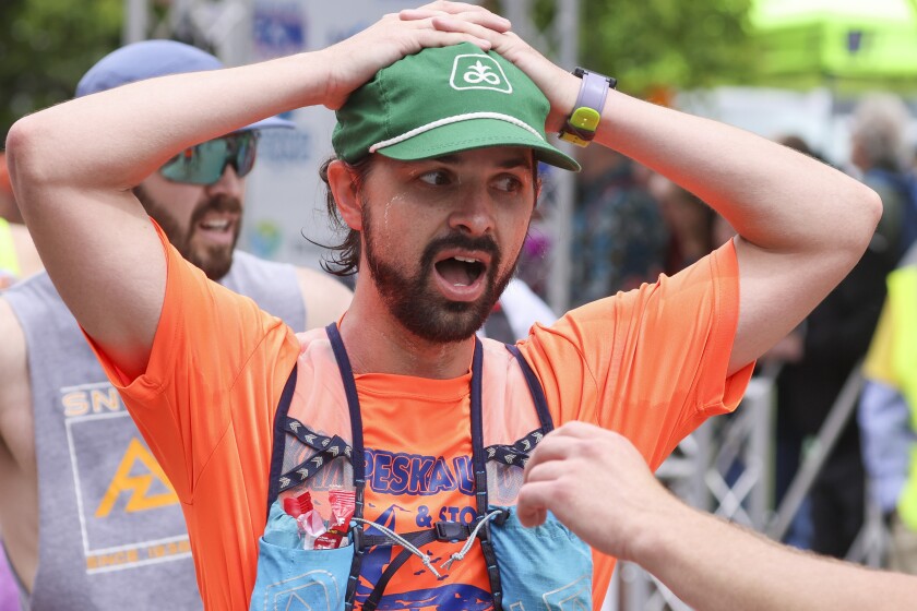 Athletes running and celebrating at the finish line area of Grandma's Marathon