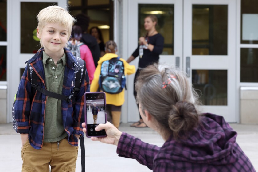 Woman photographs her son.