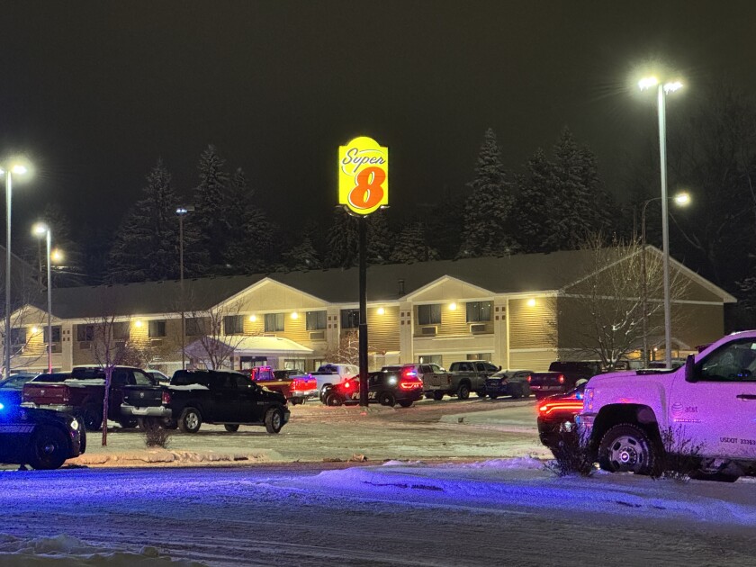 Police cars parked near Super 8 motel with lights flashing