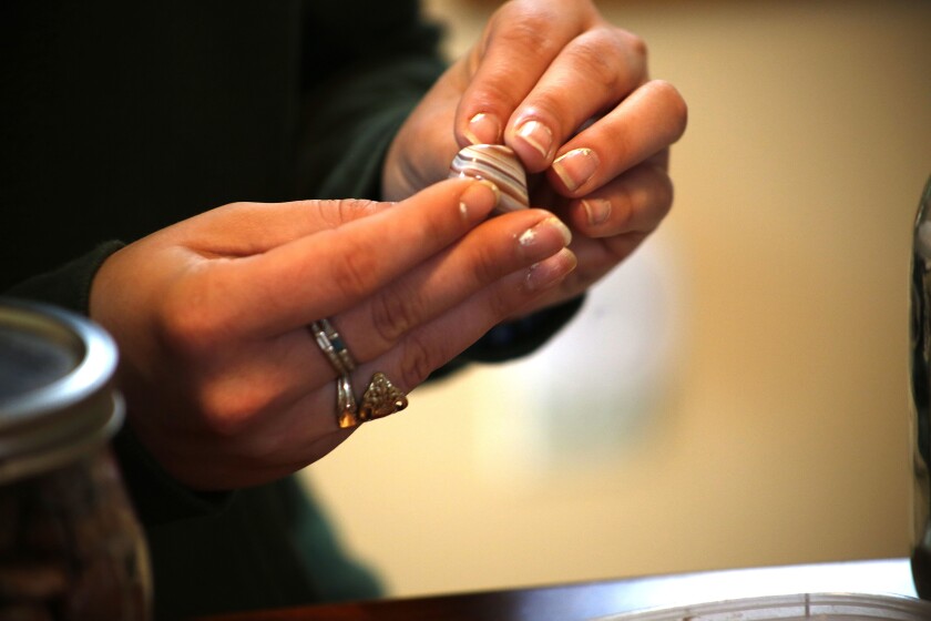 A woman holds an agate.