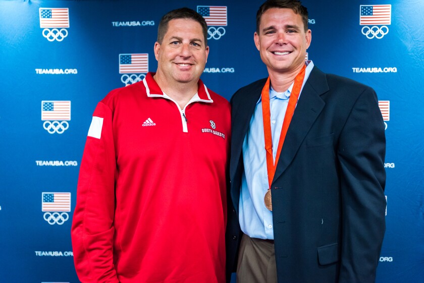 South Dakota track and field coaches Lucky Huber and Derek Miles pose for a photo after Miles received his Olympic bronze medal in pole vaulting Monday, April 17, 2017, at the DakotaDome in Vermillion.