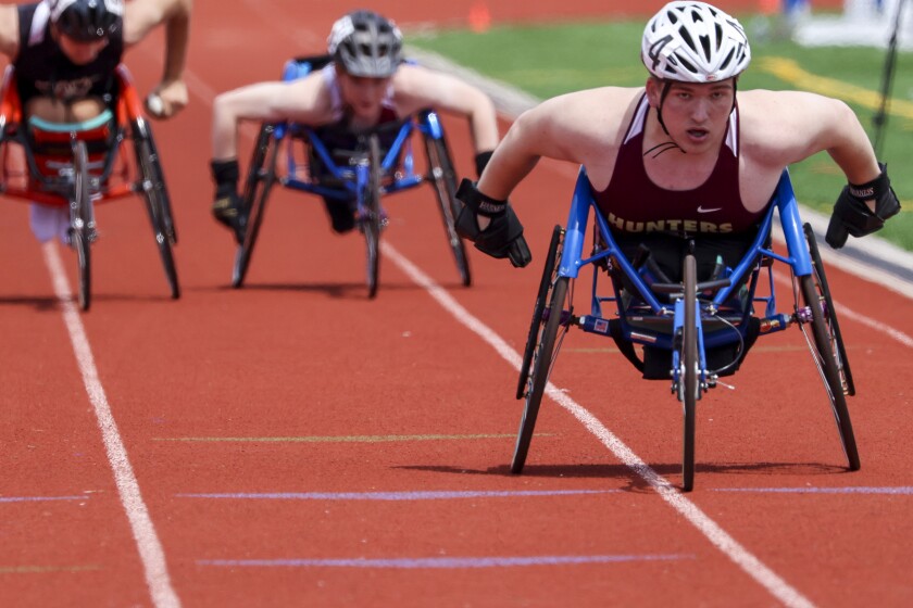 High school athletes compete in track and field events at outdoor stadium