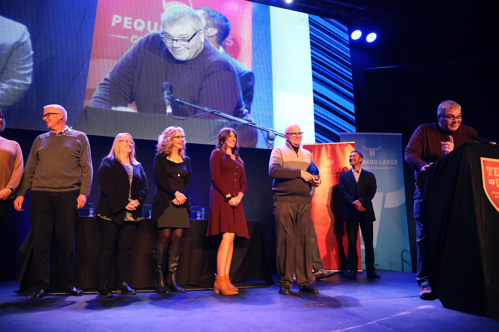 People stand on stage while accepting an award