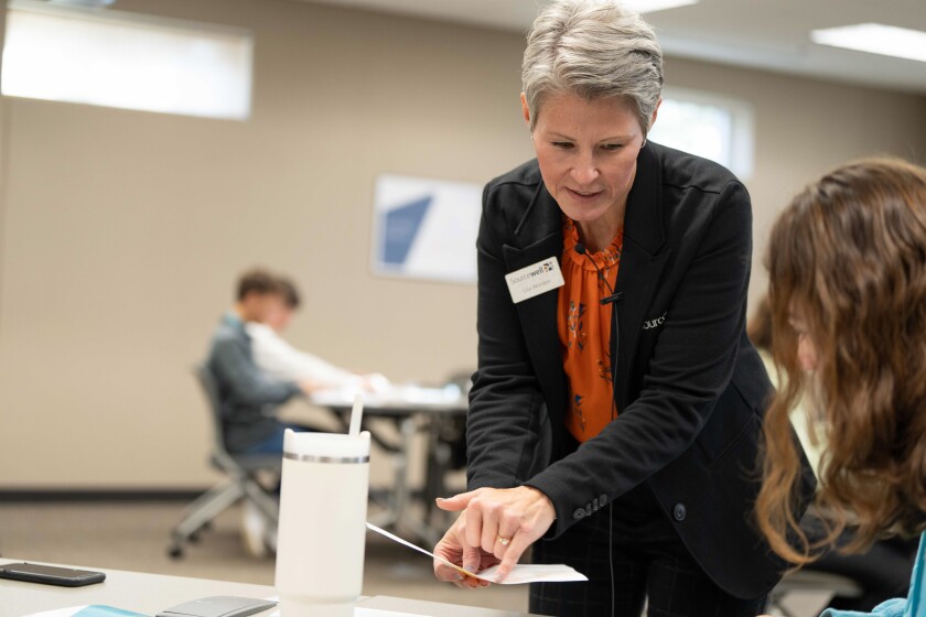 Sourcewell education consultant Lisa Worden helps a selected high school student at the all-day 2023 Student Leadership Conference hosted by Sourcewell at Central Lakes College in Staples on Oct. 23, 2023.