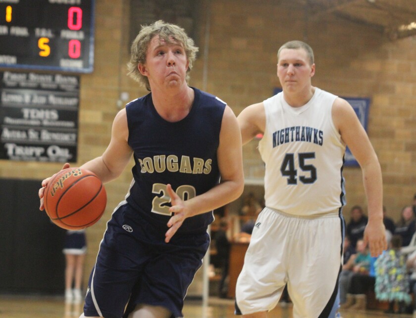 Burke/South Central's Ethan Fernau (20) tries to convert a layup while Tripp-Delmont/Armour's Noah Schafers (45) defends the perimeter at a boys high school basketball game on Friday in Tripp. (Garrick Hodge/Republic)