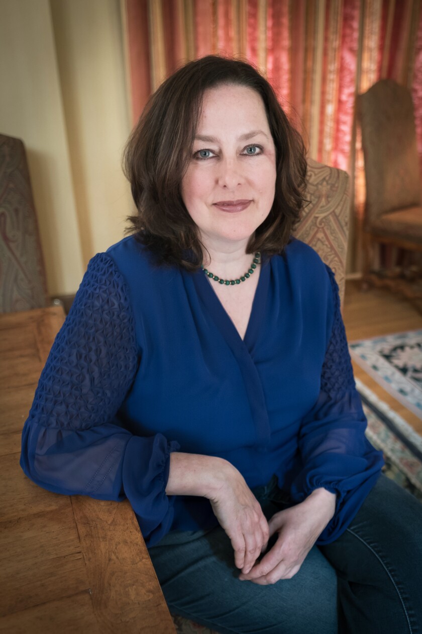 A picture of author Liz Kelly wearing a blue shirt.