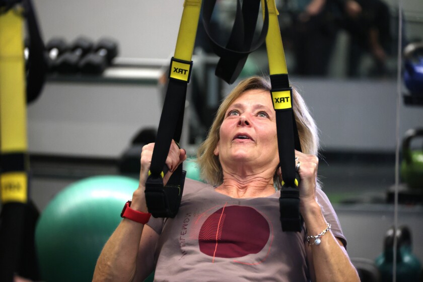 Woman finishes pull-up during fitness class