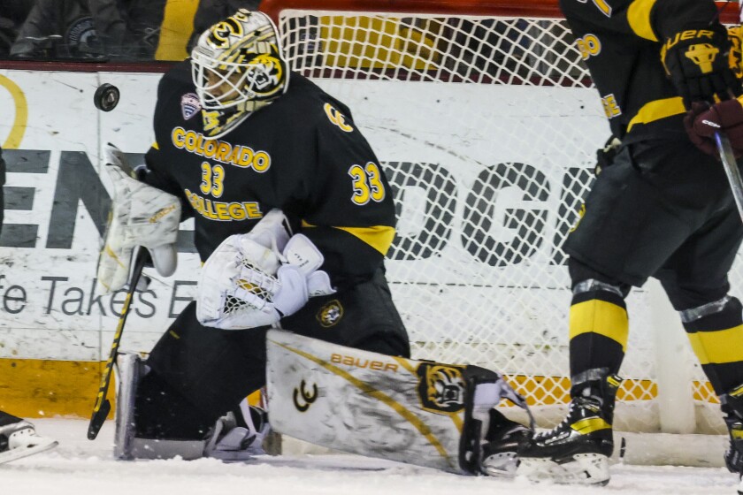men's hockey players compete in game at indoor arena