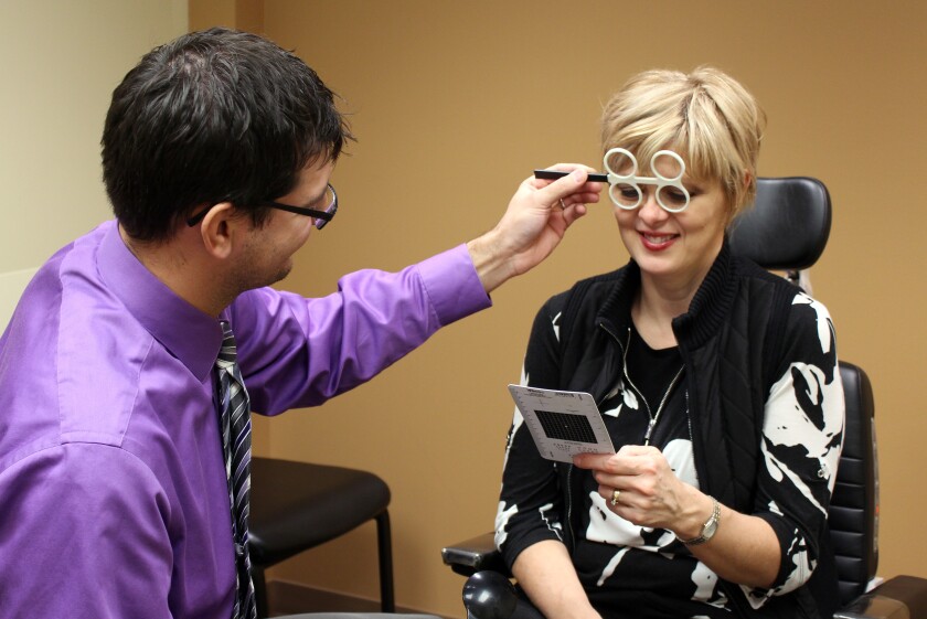 Dr. Alexander Moses, an ophthalmologist at Essentia Health-St. Mary's in Detroit Lakes, checks the eyes of patient Kristi Brend. Brend, an optician at Essentia Health-St. Mary's, has been showing symptoms of digital eye strain for about the past five months. Marie Johnson / Tribune