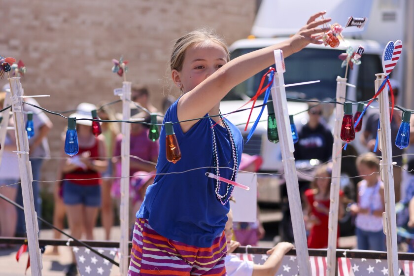 People wearing red white and blue patriotic themed clothing participating in outdoor parade