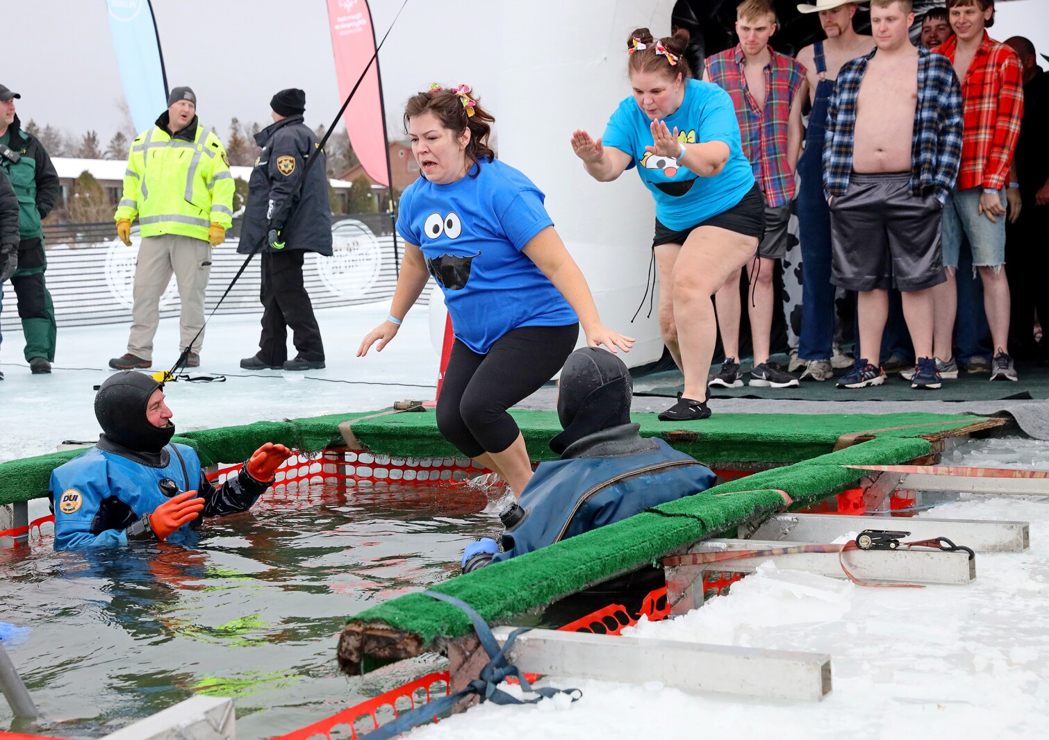 People jump into the water during the Polar Plunge event on Pelican Lake.