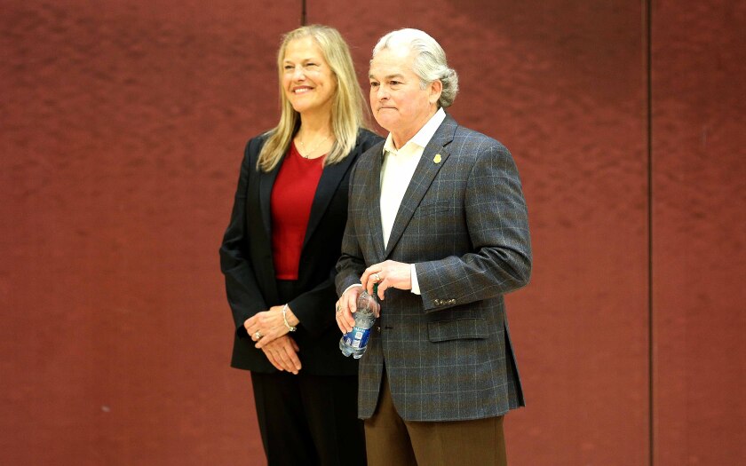 Karen Stromme and Gary Holquist listen to a speaker