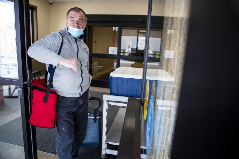 Duane Lardy brings food outside to be loaded up for Meals on Wheels at West Central Industries on Friday, May 20, 2022.