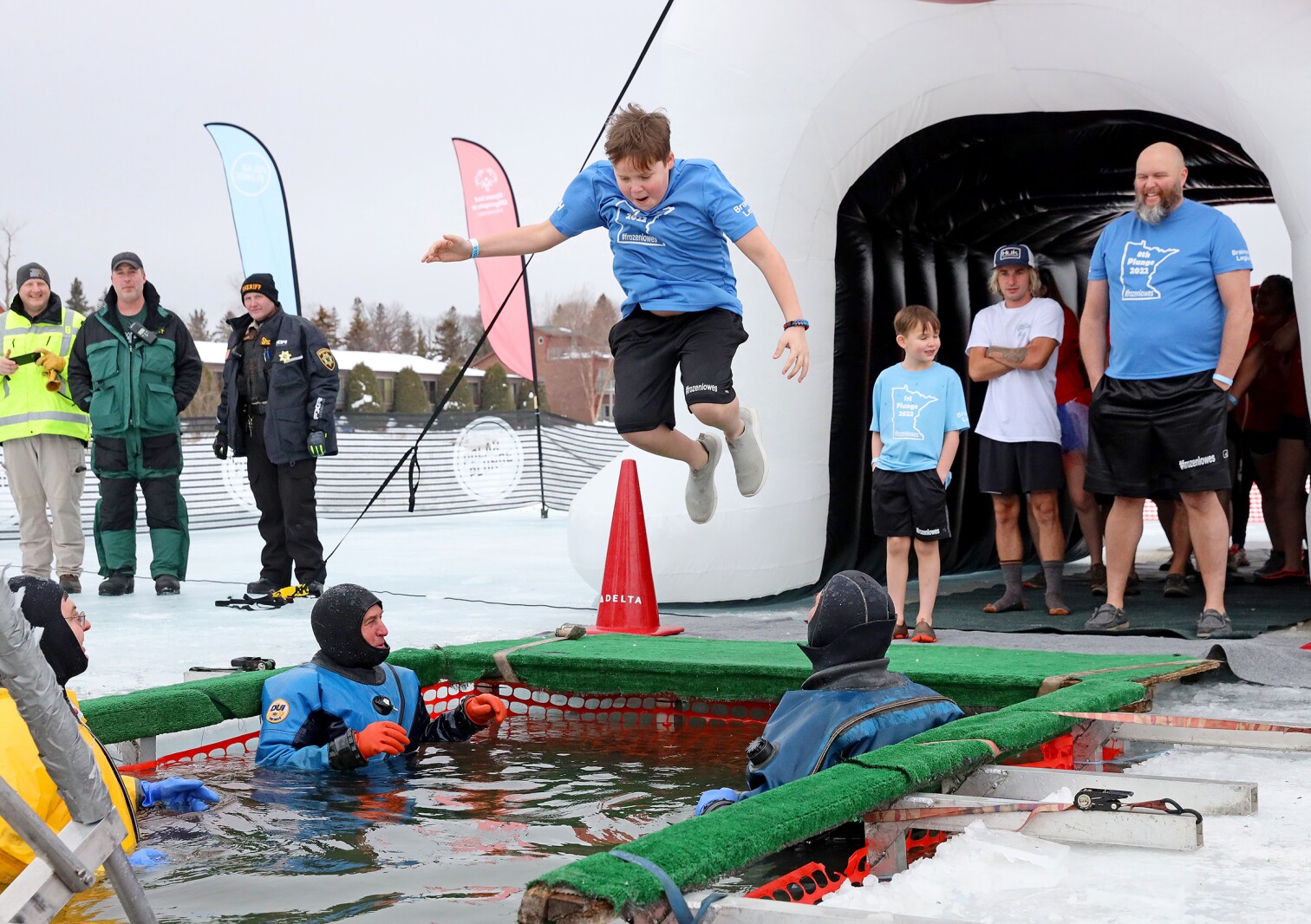 People jump into the water during the Polar Plunge event on Pelican Lake.