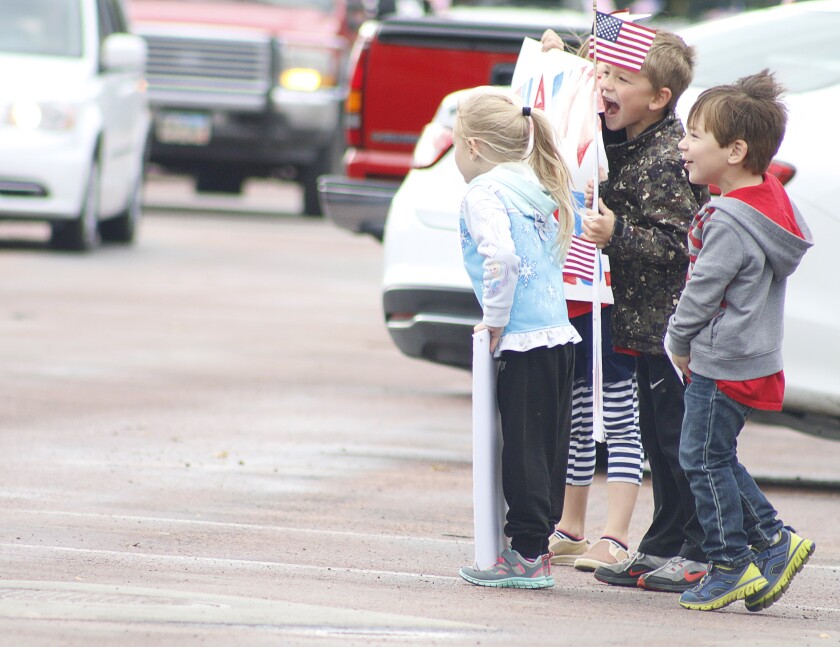 Children cheer as cars full of soldiers with the 153rd's Forward Support Company drive by Saturday afternoon in Parkston. (Caitlynn Peetz/Republic)
