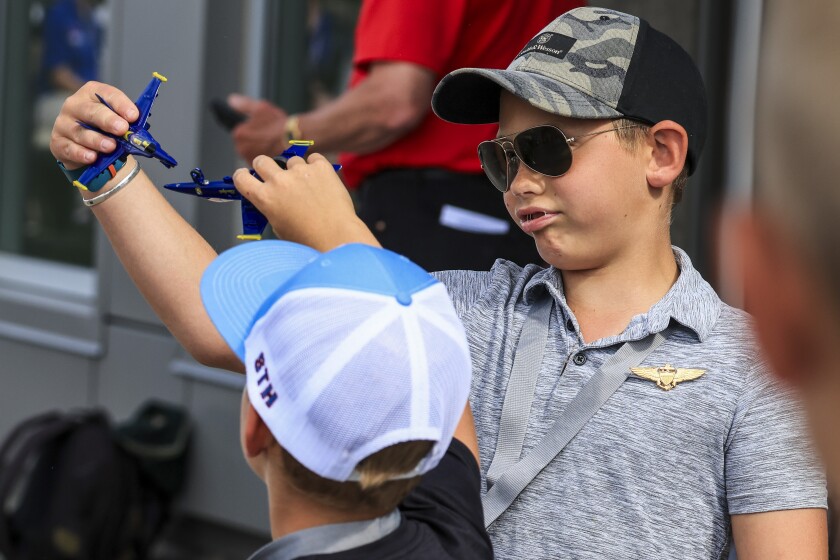 two boys play with airplanes