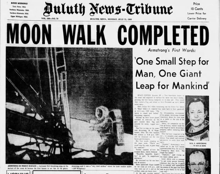 Přední stránka historických novin ukazující astronaut, který odstoupil na Měsíc