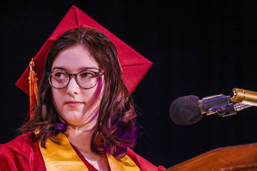 Students in maroon robes graduate