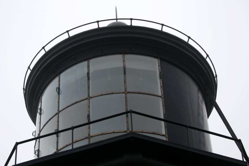 An unlit beacon at a lighthouse during the daytime.