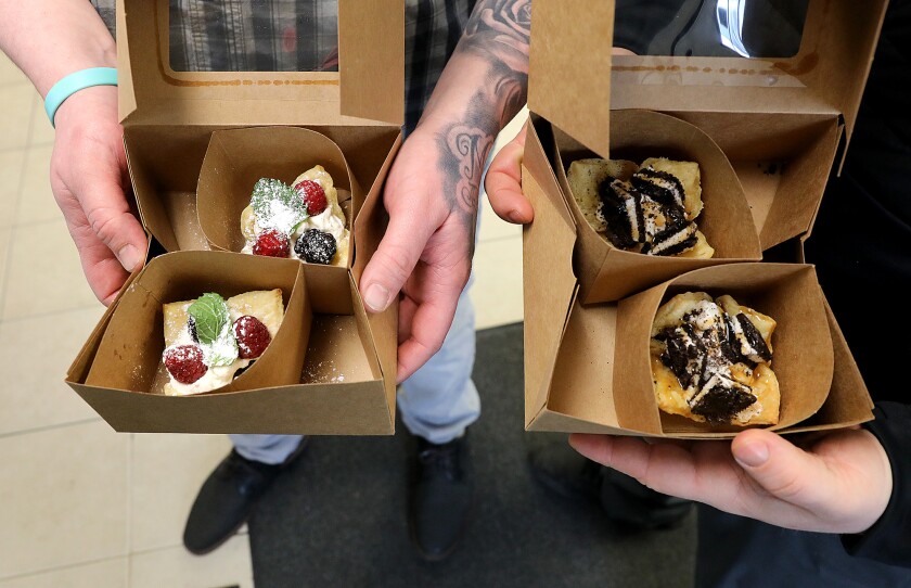 Chefs Paul Lukens, left, and Jeremy Wilson hold a sample of some of the treats offered by Superior Roux