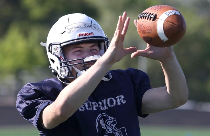 Superior quarterback Carson Gotelaere catches a pass during practice