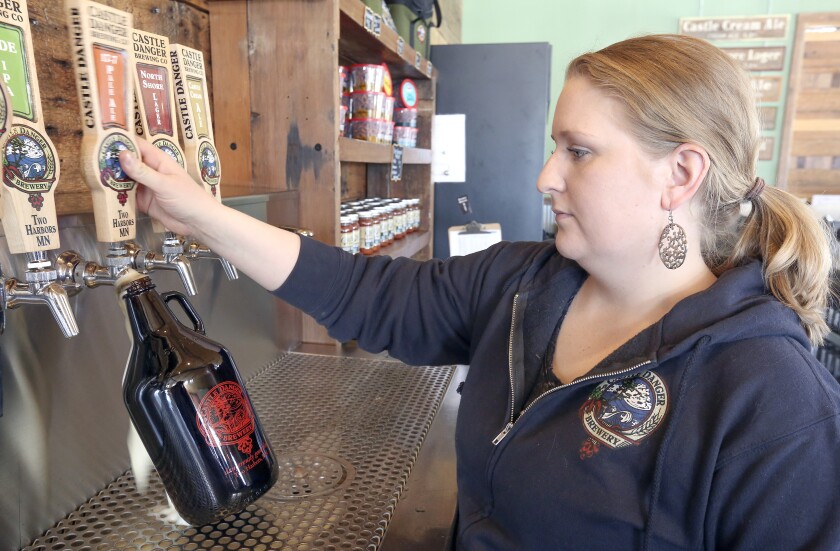 Castle Danger Brewery employee Erin Cole fills a growler at the Two Harbors taproom recently. Castle Danger’s annual production is nearing 20,000 barrels, above which it will not be allowed to sell growlers unless state law is changed. Steve Kuchera / skuchera@duluthnews.com