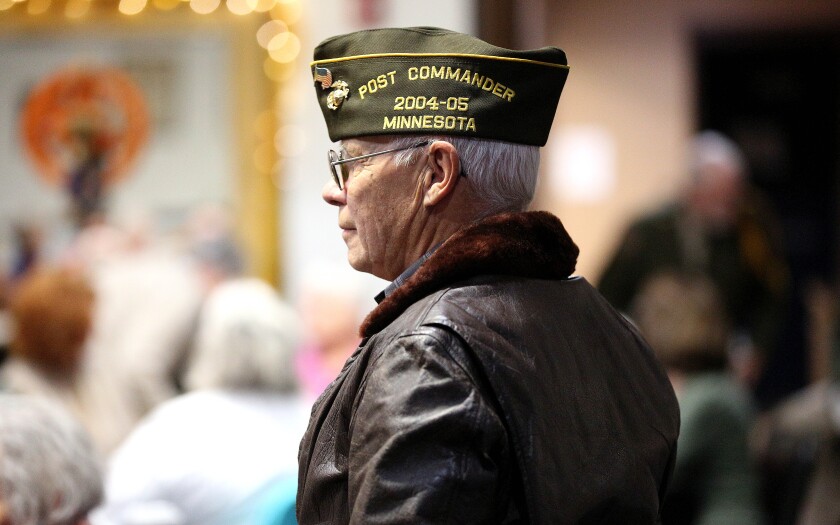 A U.S. Marine Veteran standing during a Veterans Day event.