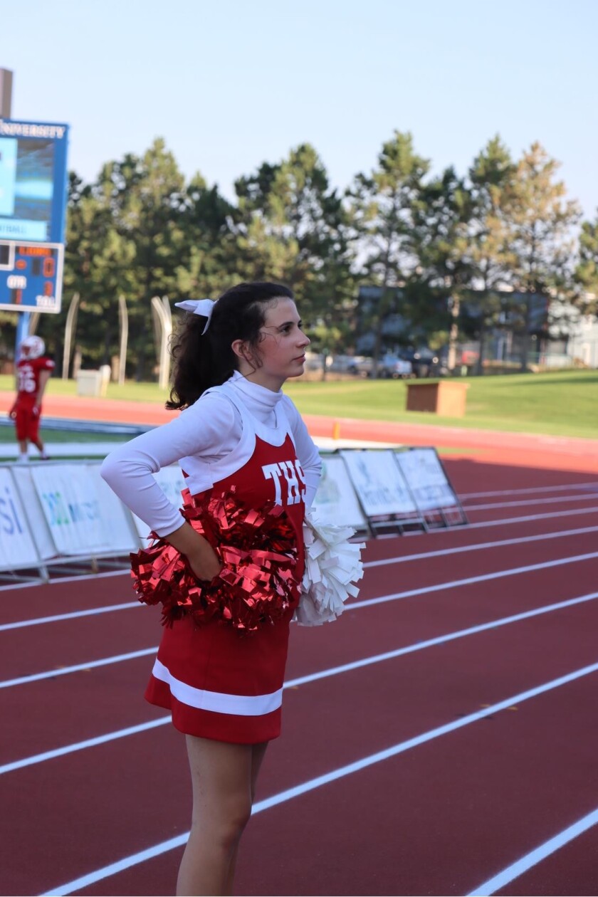 As part of his extracurricular activities, Trinity senior Brooklyn Berger cheers on his fellow Titans during a football game.