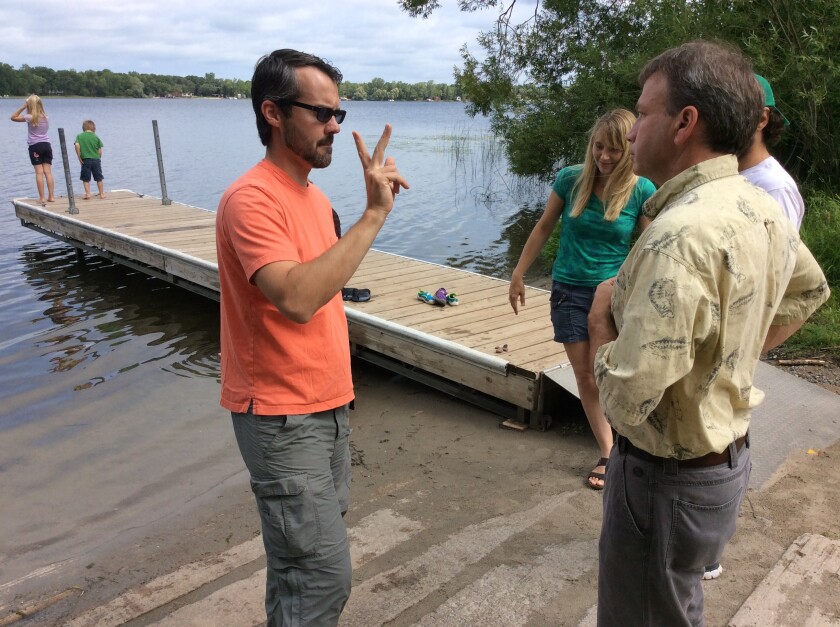 Gallaudet University associate professor Daniel Lundberg (left) signs to Central Lakes College natural resources instructor Kent Montgomery late last week at Crow Wing Lake.