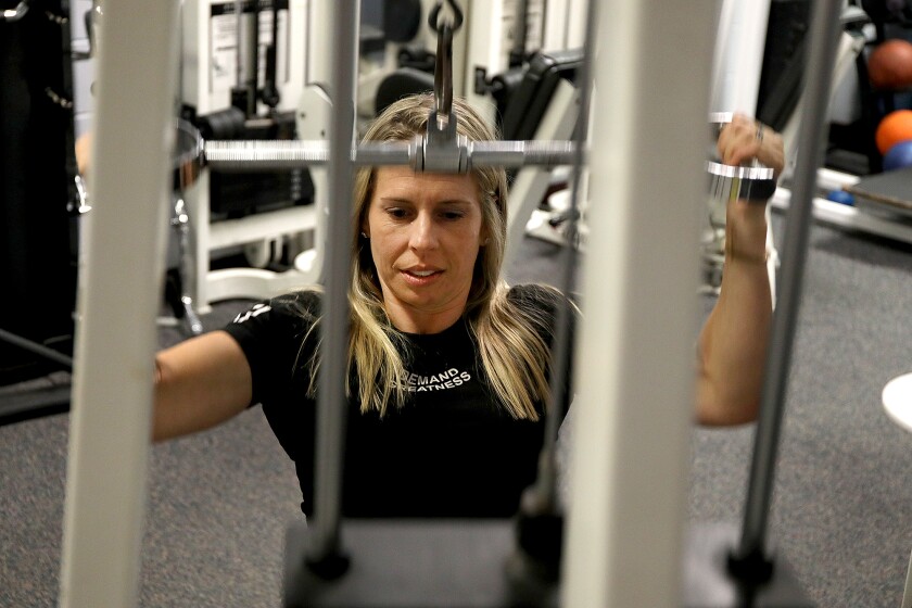 Powerlifter Char Balcer warms up on a pull-down machine