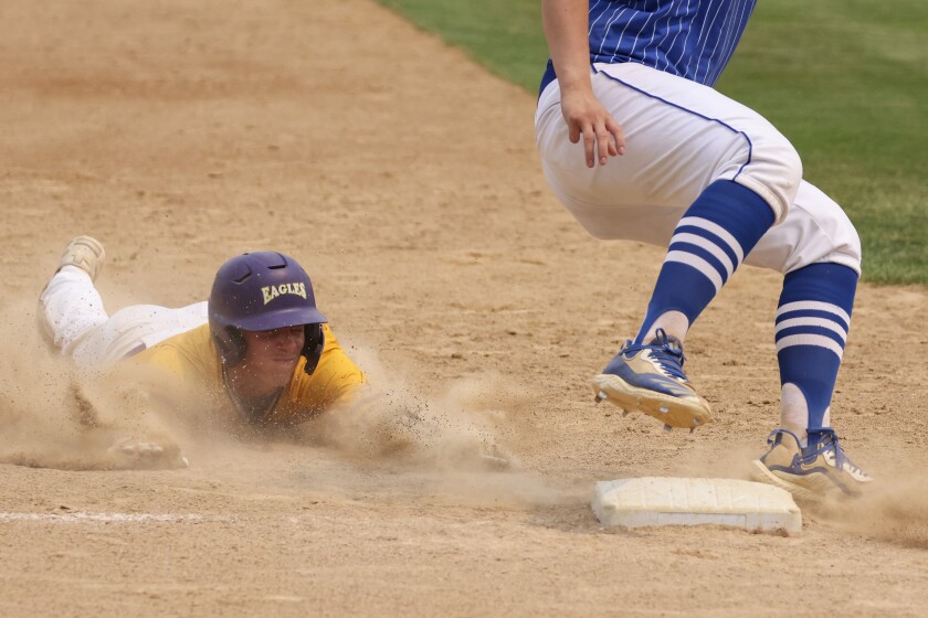 High school baseball players play on outdoor field on sunny day