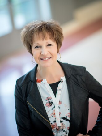 A woman with short hair poses for a portrait.