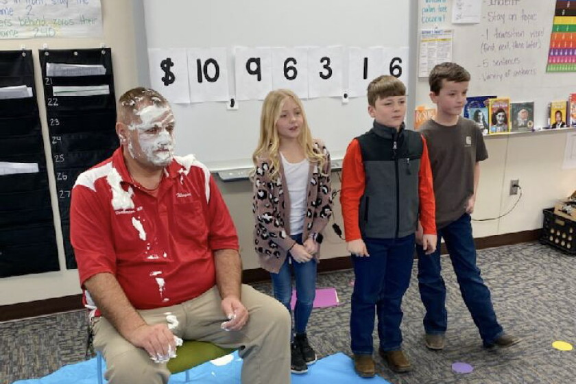 Wayne Verdoorn, custodian at Prairie Elementary, stands with fourth graders Kaylee Raymo, Hendrik Ahlers and Dyson Neugebauer as they announce the school raised $10,963.16 for Children's Miracle Network this year. Verdoorn was pied in the face three times as part of the fundraising festivities.