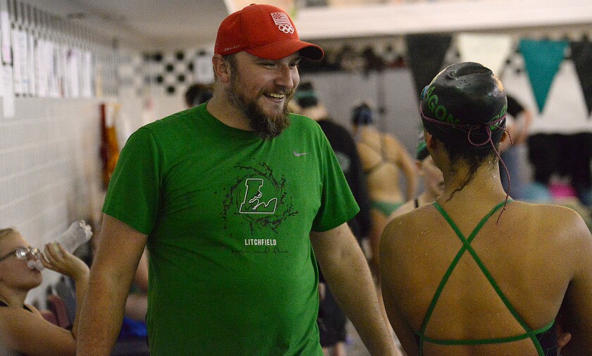 Litchfield girls swim coach Tim Hroma, left, talks to one of the Dragons' swimmers during a meet against Melrose on Tuesday, Oct. 11, 2022 at Litchfield.