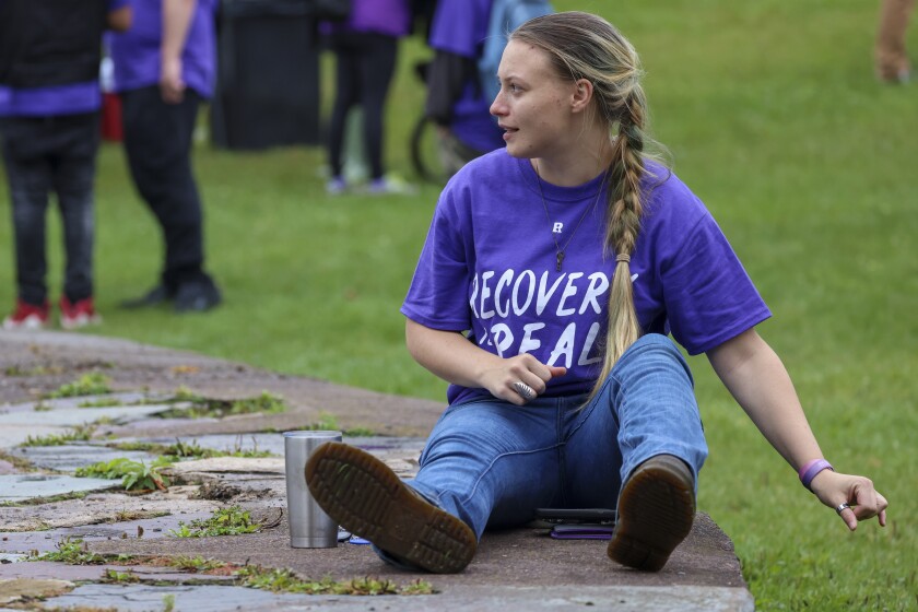 People in purple shirts celebrate recovery in outdoor park