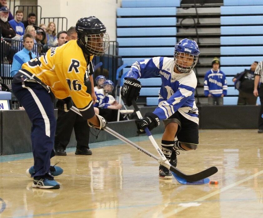 Brainerd’s Tre’Von Otey (right) works the puck around Robbinsdale defender Izear Joiner during the state championship game.