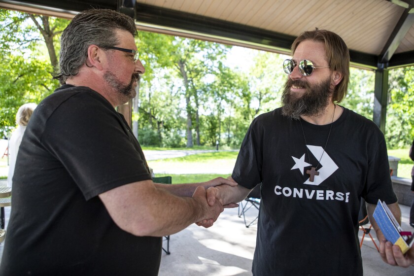 Joseph Schaeffer, at left, shakes the hand of Gerald Cloutier Jr. after Cloutier graduated from 8th Judicial District Drug Court at Robbins Island Regional Park on June 8, 2022.