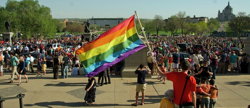 A rainbow flag flies in front of the Minnesota Capitol