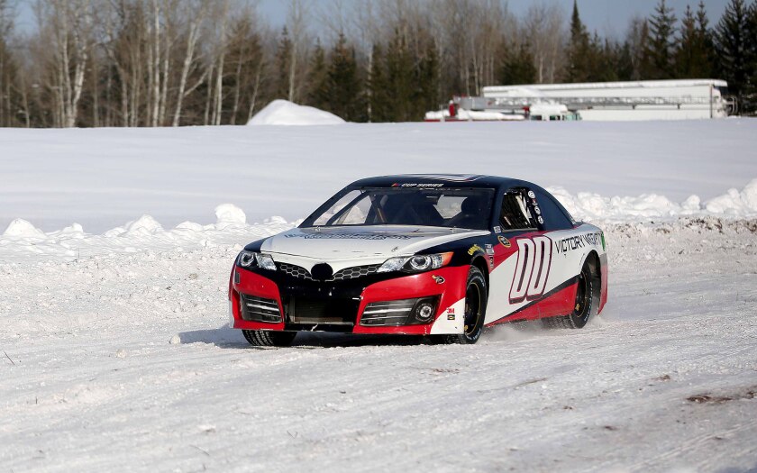 A retired NASCAR Cup Series car races on a track