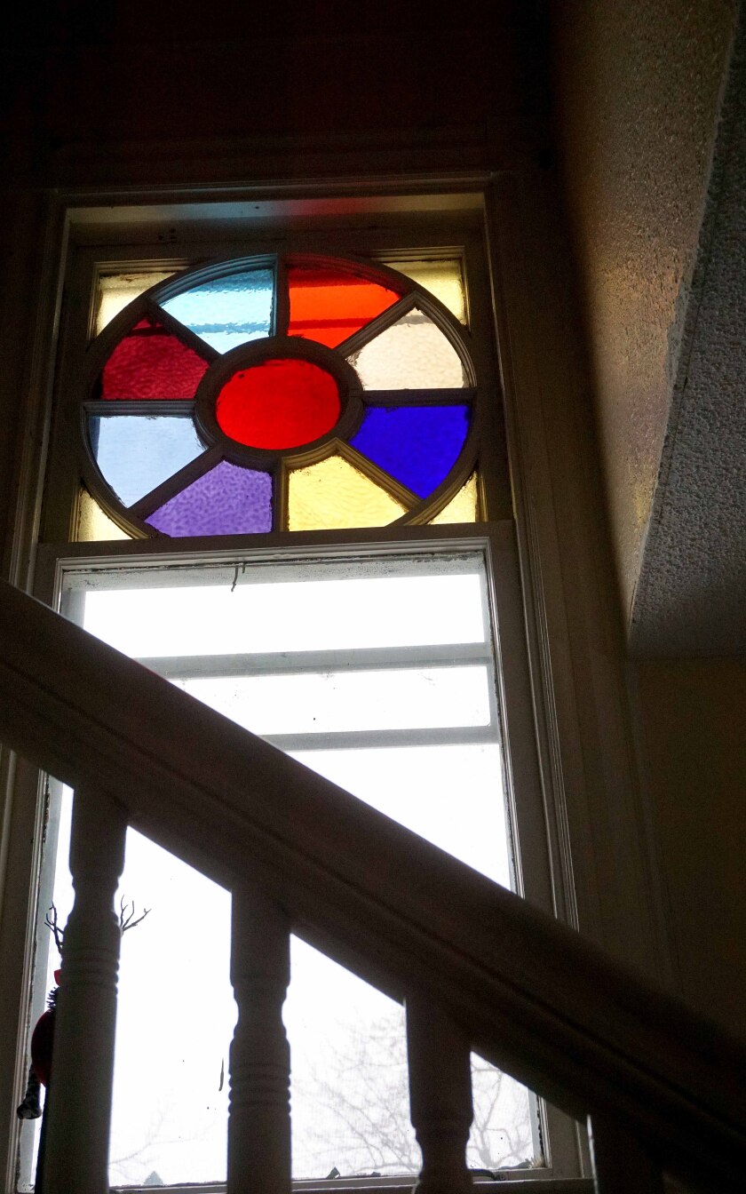 A glass window above a stairway inside of a historic home in Duluth