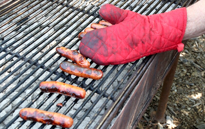 Hot dogs get rolled over the coals