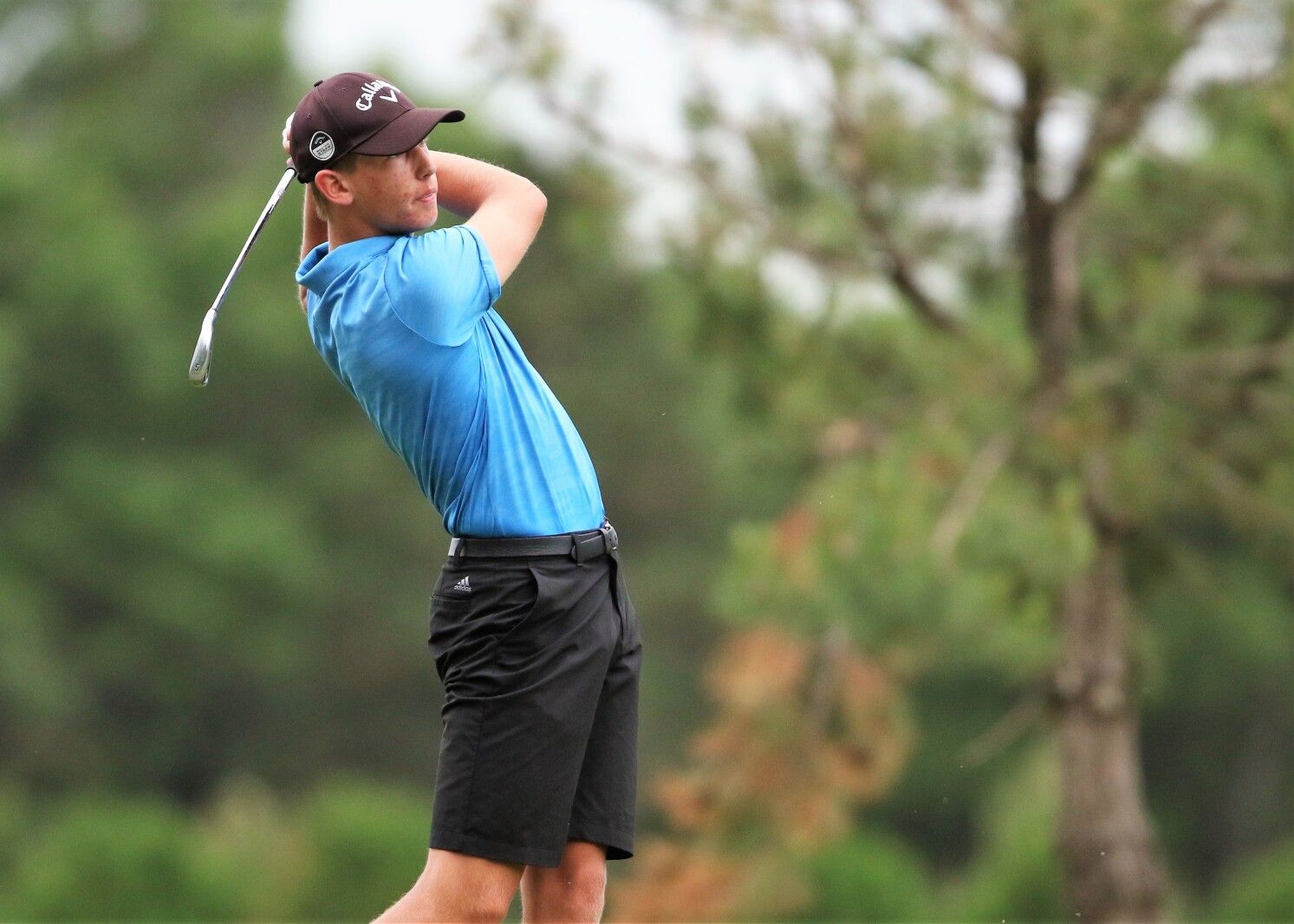 A golfer hits the ball.