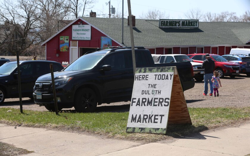 cars and a sign at the Duluth Farmers Market parking lot