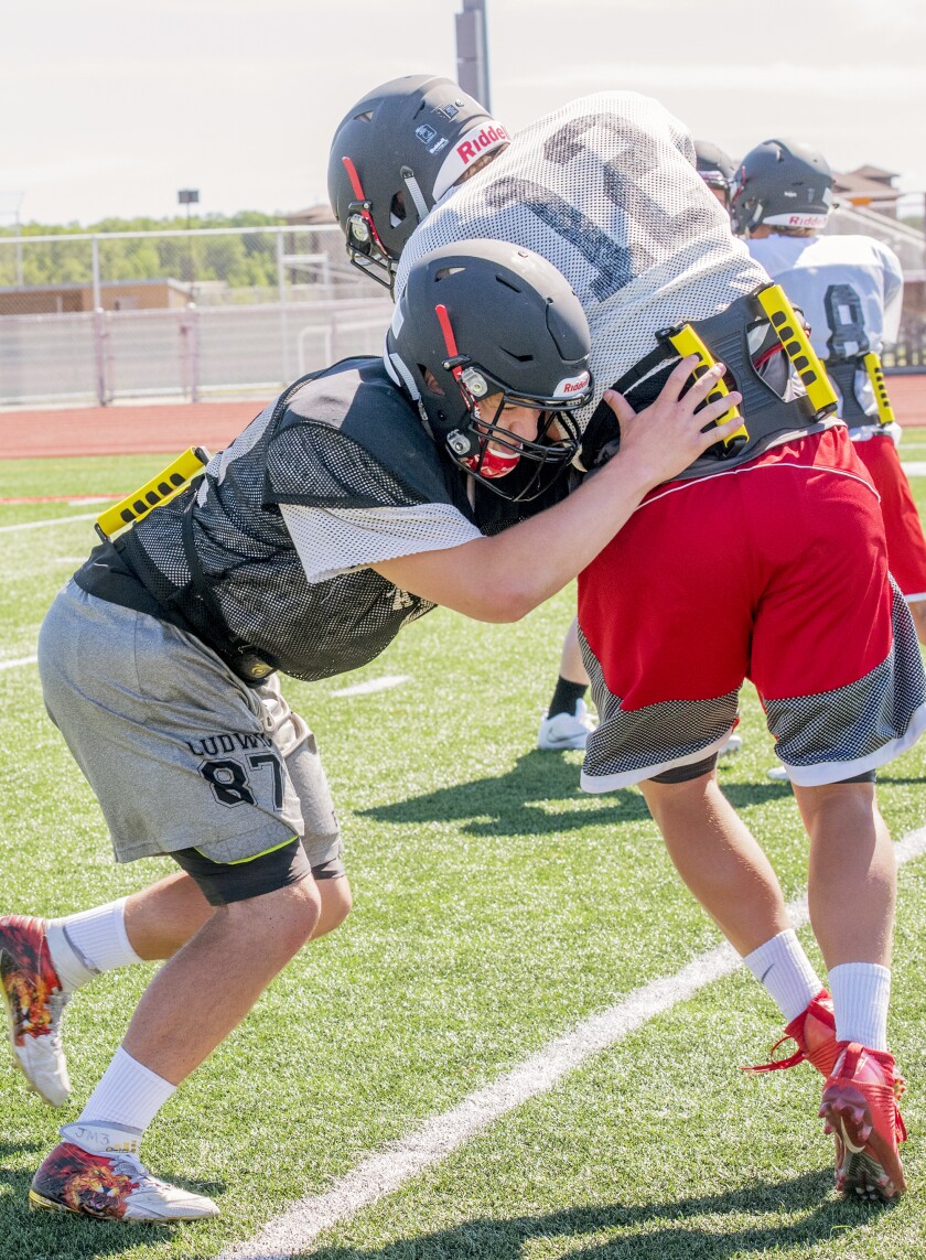 Alexandria's Bryce Ludwig (left) wraps up fellow senior Michael Empting during one of Alexandria's practices this past fall season using the Tacklebar. (Submitted photo from Tacklebar)