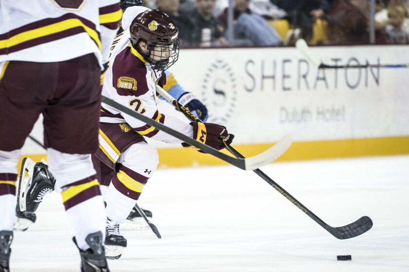college men play ice hockey indoors